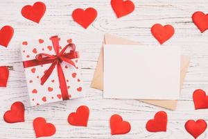 Envelope Mail with Red Heart and gift box over White Wooden Background. Valentine Day Card, Love or Wedding Greeting Concept photo