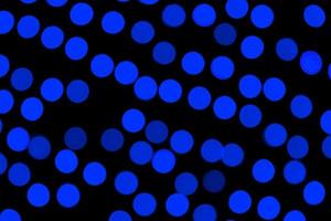 Unfocused abstract dark blue bokeh on black background. defocused and blurred many round light photo