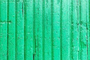 Bright green wooden background with peeling paint and vertical boards photo