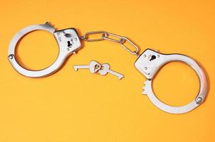 Handcuffs on yellow background photo