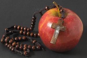 Sin concept with apple and crucifix photo