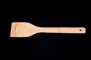 Wooden spoon on black background photo