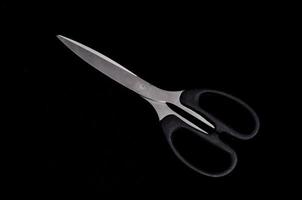 Scissors on black background photo