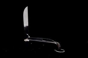 Folding knife on black background photo