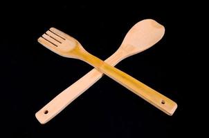 Wooden cutlery on black background photo