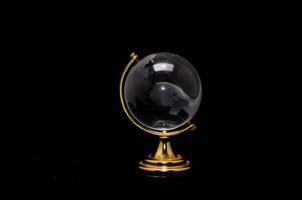 Glass globe on black background photo