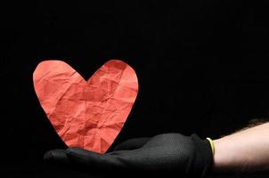 Hand holding a paper heart photo