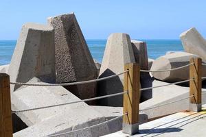 el rompeolas protege la playa a la orilla del mar de las grandes olas. foto