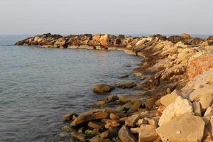 The breakwater protects the beach on the seashore from big waves. photo