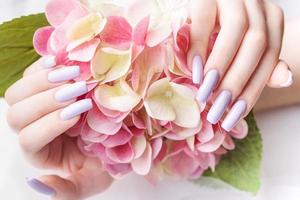 Girl's hands with a soft purple manicure. photo