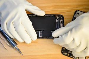 Top view of a technician repairing a smartphone photo