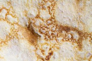 Pancake surface texture and pattern. Close-up of thin hot pancakes in a plate. Traditional rustic food. Graphic resource. photo