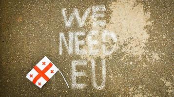 Georgian flag lay on ground by written statement we need EU. Integration process to EU concept photo