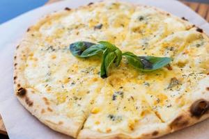 Fragrant Italian pizza of four cheeses - parmesan, dor blue, mozzarella, cheddar, Close up, top view. photo