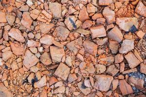 A pile of old broken red clay brick rubble after demolition of an old building lies on the ground on a building site. photo