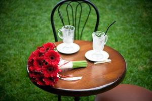 red bridal bouquet and cappuccino, coffee cup photo