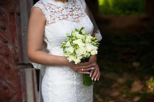 Bride holding wedding flower bouquet of roses. photo