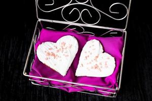 Cookies in the form of heart lies in a casket with a pink towel, close-up photo