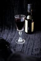 glass of red wine on a black velvet background, close-up photo