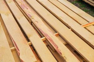 Building material in the form of fresh wooden planks at a road repair site. The repair process. View from above. photo