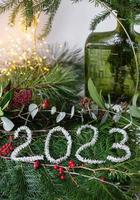 2023 new year green background from live leaves and branches. Seasonal packaging and New Year's paraphernalia. New Year's composition, a ready-made opening. photo