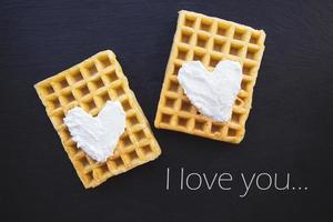 Delicious Belgian waffles with cream on a black background-inscription I love you. photo