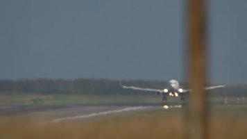 avion atterrissant sur la piste vue à travers une forte vibration de brume de chaleur et un mirage en été chaud video