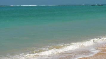 hermosa ola en la playa, agua clara, arena amarilla en el mar de andaman phuket tailandia. video