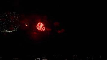 Brightly colorful fireworks in the night city at a festive event. Holiday concept. New Year's and Christmas video