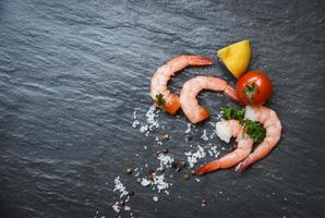 Seafood shrimp on top view Shellfish fresh shrimps prawns ocean gourmet with tomato lemon and green parsley photo