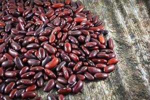 frijoles rojos azuki o semillas de grano de frijol rojo sobre fondo de madera rústica