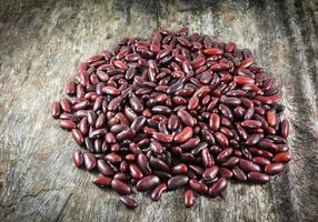 frijoles rojos azuki o semillas de grano de frijol rojo sobre fondo de madera rústica foto