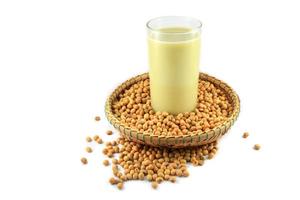 Soy milk in the glass and soybean seeds on threshing basket isolated on white background - soya beans photo