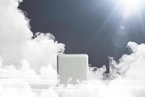 A pedestal in the form of a white cube on a gray background with sun rays and smoke. Pedestal for product presentation. Basis for work photo