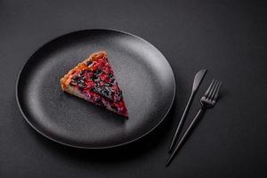 Delicious fresh pie with raspberries and other berries and cheese on a dark plate photo