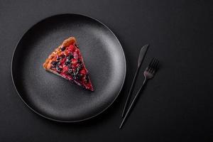 Delicious fresh pie with raspberries and other berries and cheese on a dark plate photo