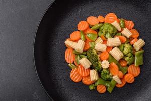 A mixture of vegetables carrots, small heads of corn, asparagus beans steamed photo