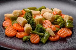 A mixture of vegetables carrots, small heads of corn, asparagus beans steamed photo