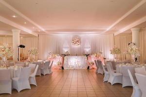 festive wedding table decoration with crystal chandeliers, golden candlesticks, candles and white pink flowers . stylish wedding day photo