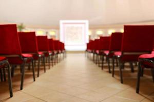 hall and empty stage, many rows of red chairs and festive velvet stage photo