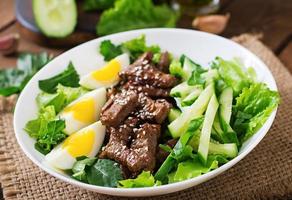 Salad with spicy beef, cucumber and eggs in the Asian style. photo