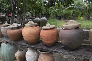 Several ancient terracotta jars with wooden lids on top. photo