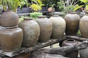 Several ancient terracotta jars with wooden lids on top. photo