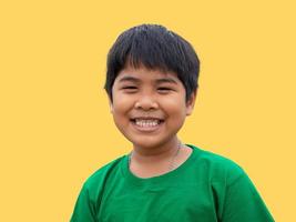 The boy wore a green shirt and stood smiling. on a yellow background photo