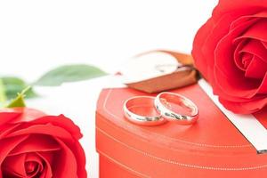 Red rose and heart-shaped box on white photo