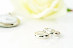 anillo de bodas y rosa blanca