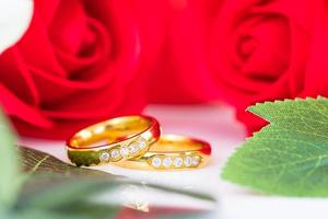 Close up Gold ring and Red roses on white photo