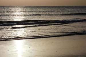 Sun setting over the sea, sunset in autumn on the beach of Zahara de los atunes, Cadiz, Andalucia, Spain photo