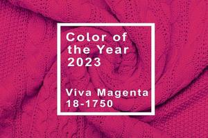 The texture of warm knitted sweater. Beautiful handmade knitted repeating pattern. Demonstrating Pantone color of the year 2023 viva magenta photo