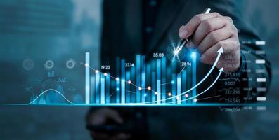 Businessman holding pen growth graph and progress of business and analyzing financial and investment data planning and strategy, Stock market, progress or success concept. photo